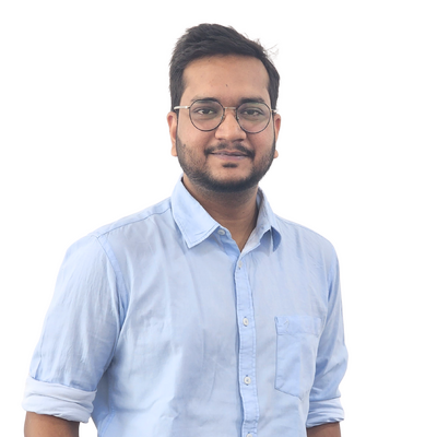 Close-up portrait of a male team member wearing glasses and a light blue shirt against a plain background