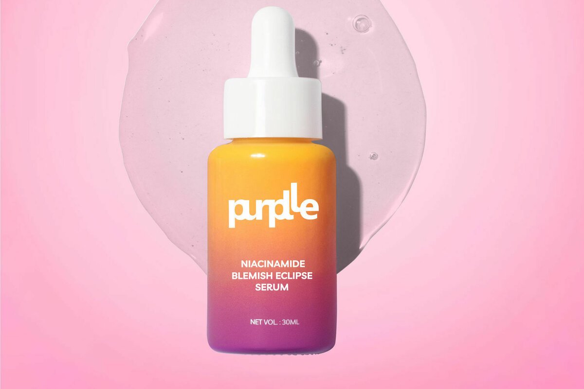 Image showing product bottle labeled purplle niacinamide blemish eclipse serum 30 mL against a pink background with liquid texture